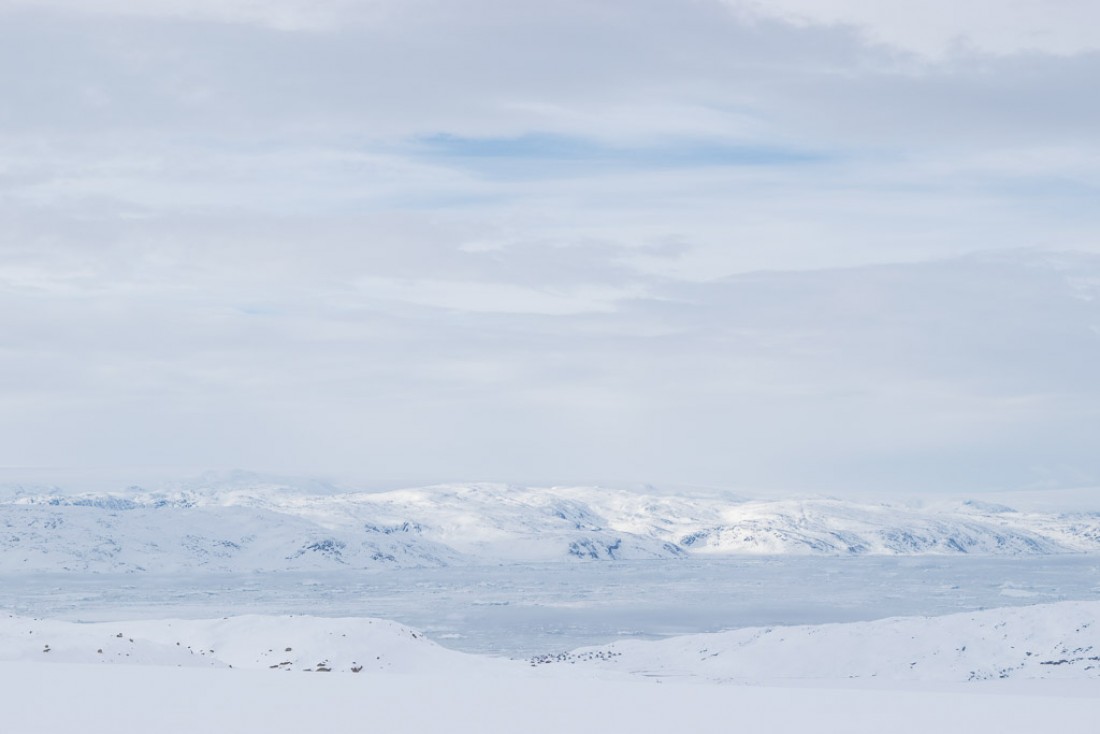 Les maisons de Tiniteqilaaq apparaissent minuscules au bord du fjord de Sermilik.