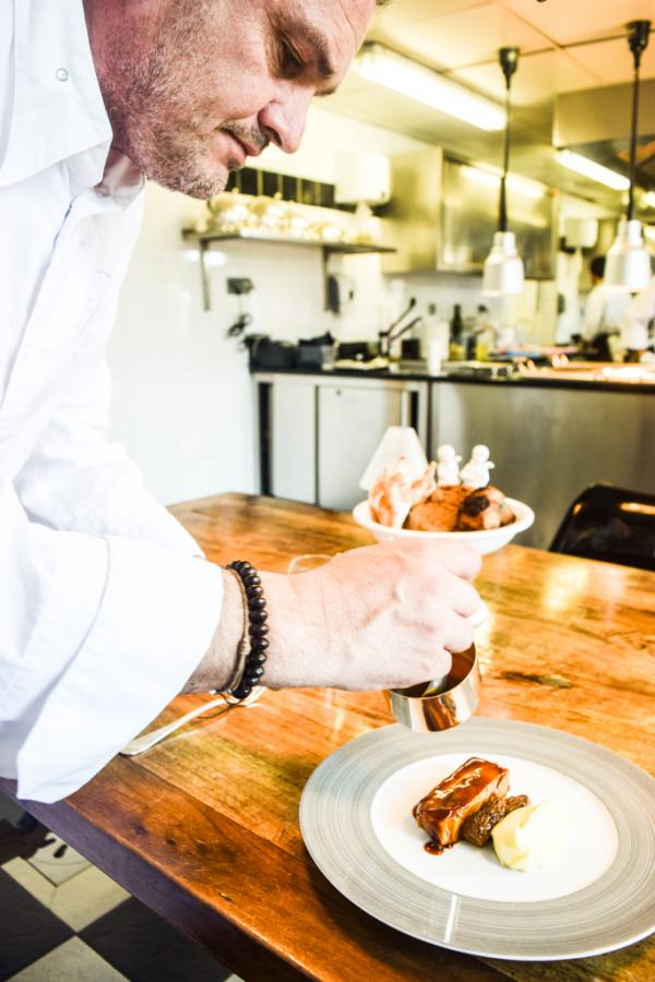 À la table d'hôtes de la Villa Archange, le chef Bruno Oger verse lui-même le jus de son inoubliable jarret de veau © Yonder.fr