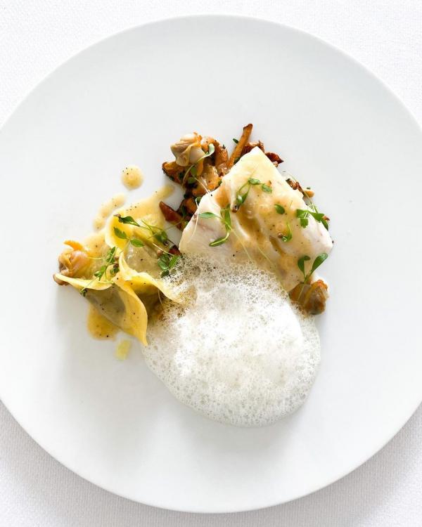Loup confit aux coquillages, girolles & ravioles d’aubergines fumées © Instagram de La Réserve Rimbaud