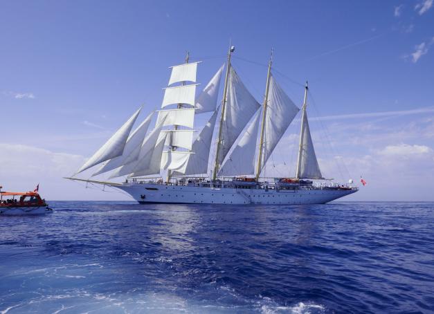 Ses 16 voiles dehors, le Star Flyer fend les eaux tranquilles de la mer Tyrrhénienne au large de la Sicile, avec, en haut du mât, peut-être vous ? Une semaine de croisière en Italie, poussés par le vent.